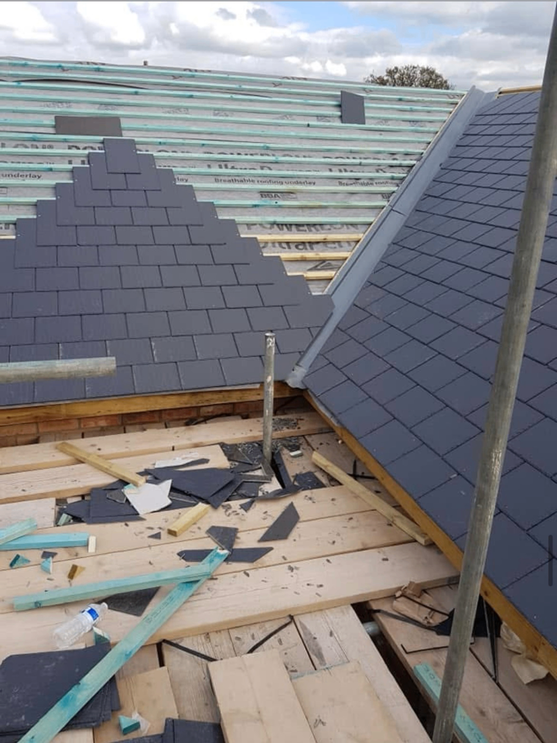 Roofer from The Roofing Lads dressing new lead flashing along a chimney abutment