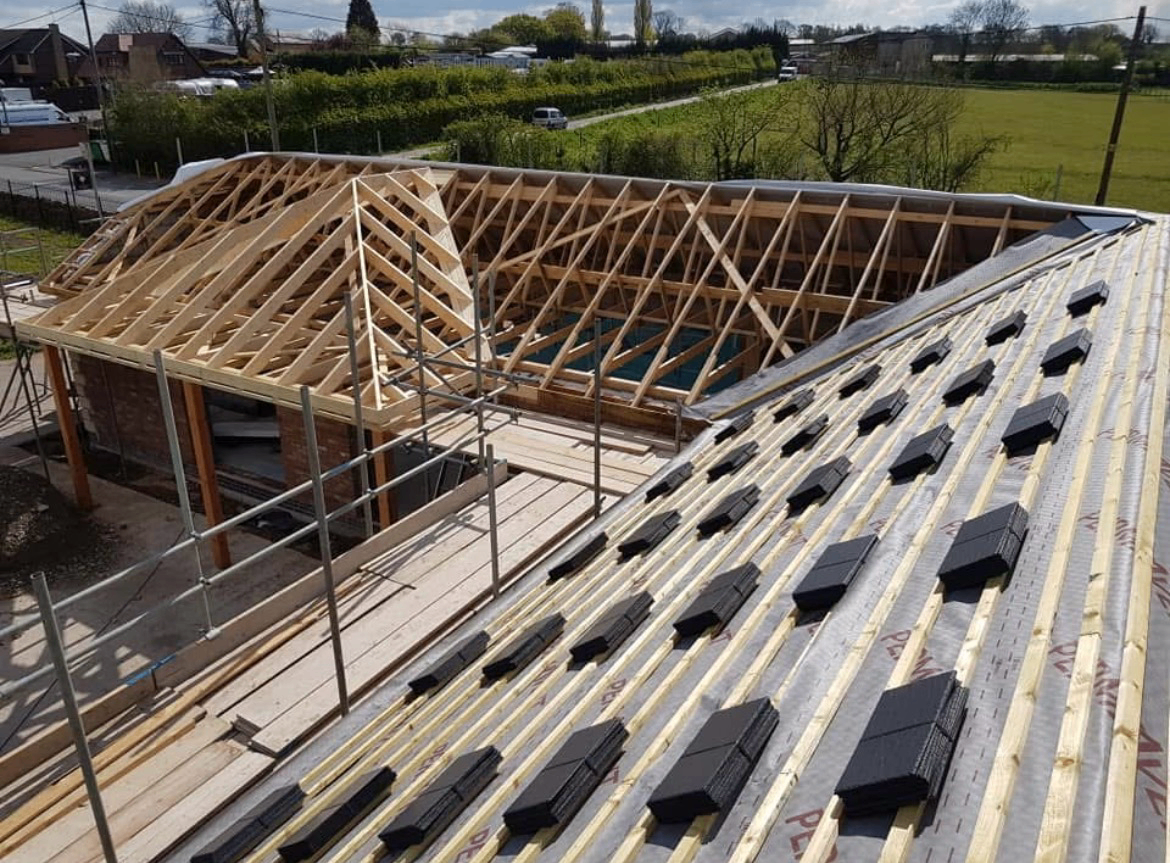 New roof structure and slate roof being built